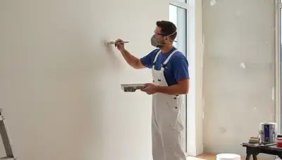 Escondido, CA painter applying touch-up paint to stucco, trim, and weathered exterior surfaces